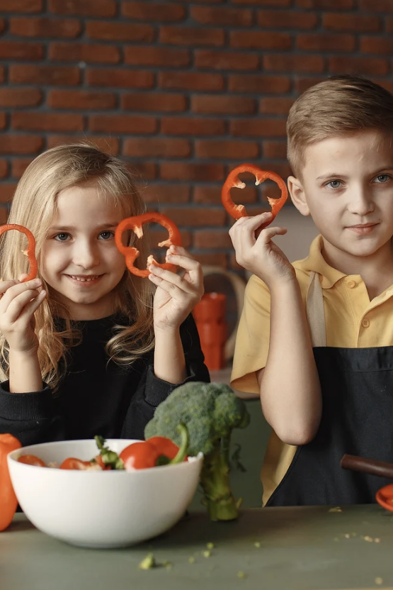 Cooking with children two children holding sliced peppers